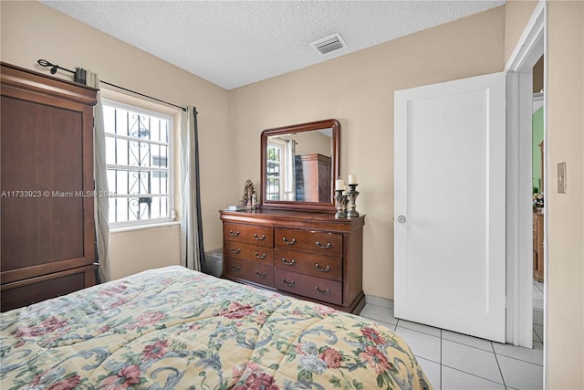 bedroom with a textured ceiling and light tile patterned floors