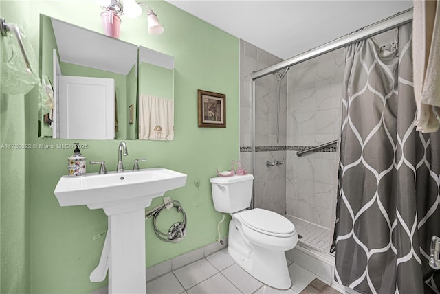 bathroom with a tile shower, tile patterned floors, and toilet