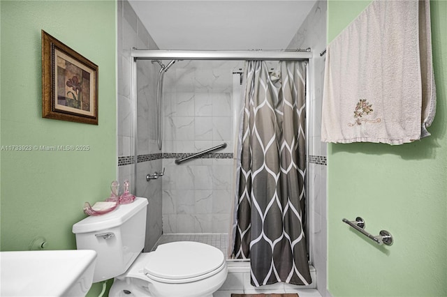 bathroom featuring a tile shower and toilet