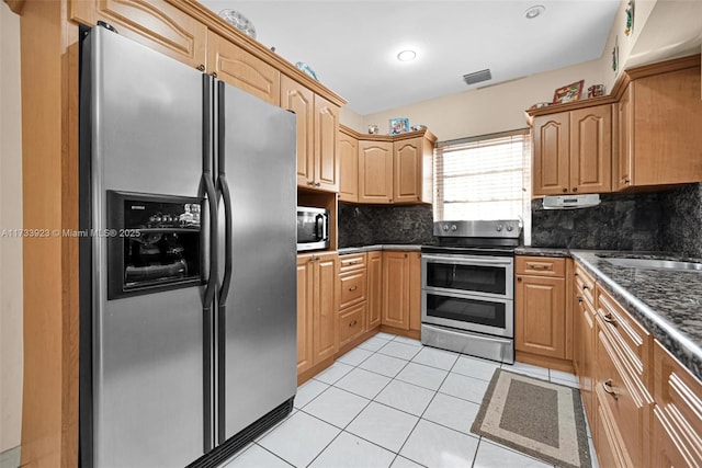 kitchen with appliances with stainless steel finishes, sink, decorative backsplash, and light tile patterned floors