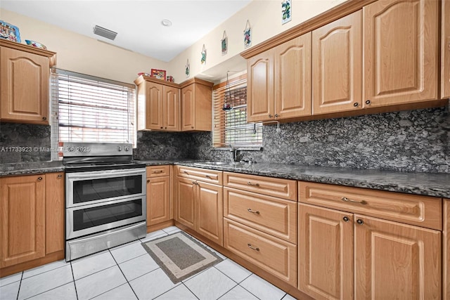 kitchen with double oven range, sink, decorative backsplash, and light tile patterned floors