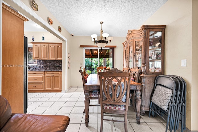 dining space featuring a notable chandelier, light tile patterned floors, and a textured ceiling