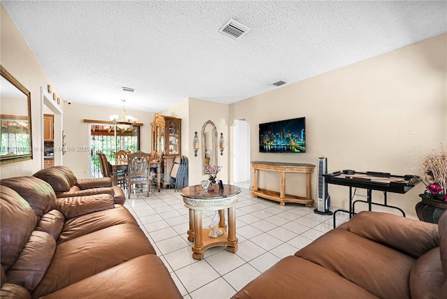 living room featuring an inviting chandelier, light tile patterned floors, and a textured ceiling