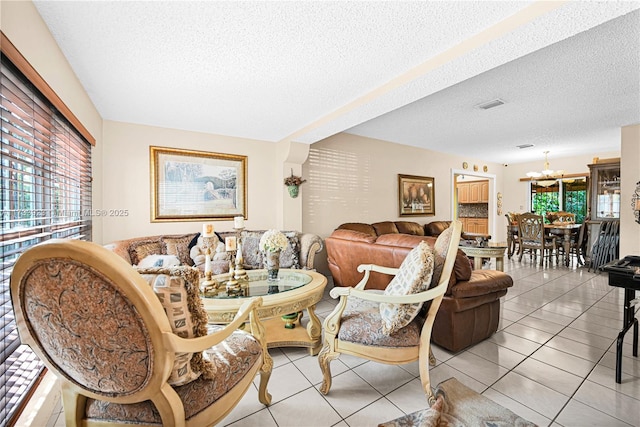 living room featuring light tile patterned floors, a textured ceiling, and a chandelier