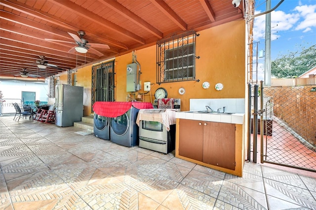 view of patio / terrace featuring ceiling fan, separate washer and dryer, and sink