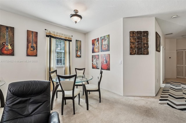 dining room featuring light carpet