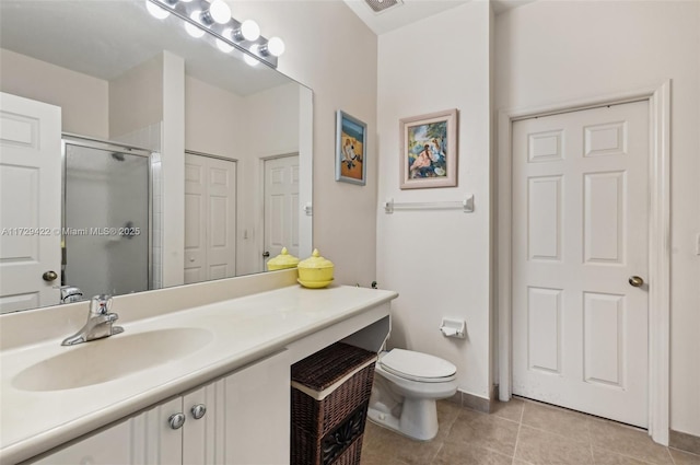 bathroom with tile patterned flooring, walk in shower, vanity, and toilet