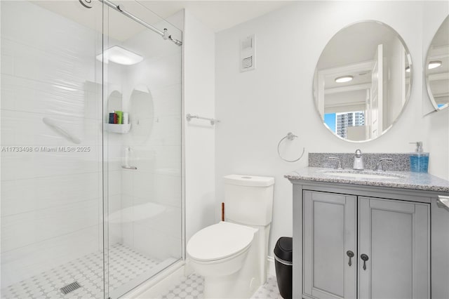 bathroom with vanity, an enclosed shower, and toilet