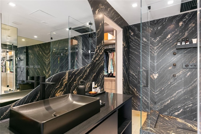 bathroom featuring tile walls, vanity, and a shower