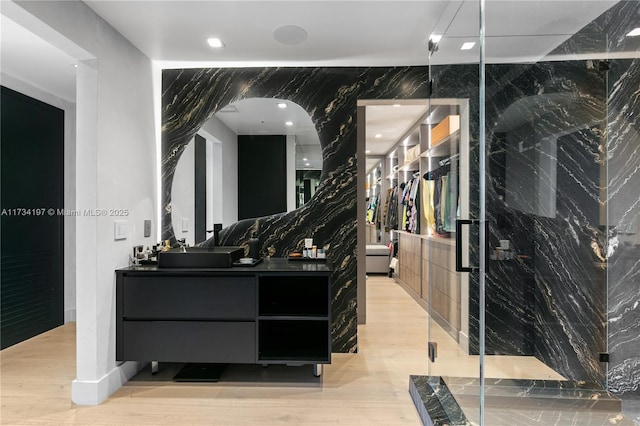 bathroom featuring vanity, tile walls, and an enclosed shower