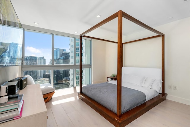 bedroom featuring a wall of windows and light wood-type flooring