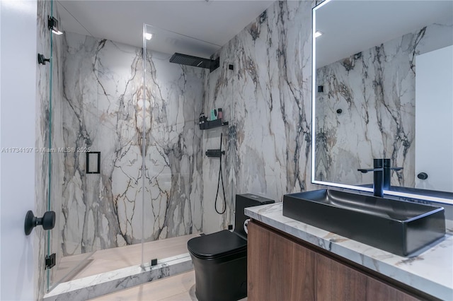 bathroom featuring tile walls, vanity, a shower with shower door, and toilet