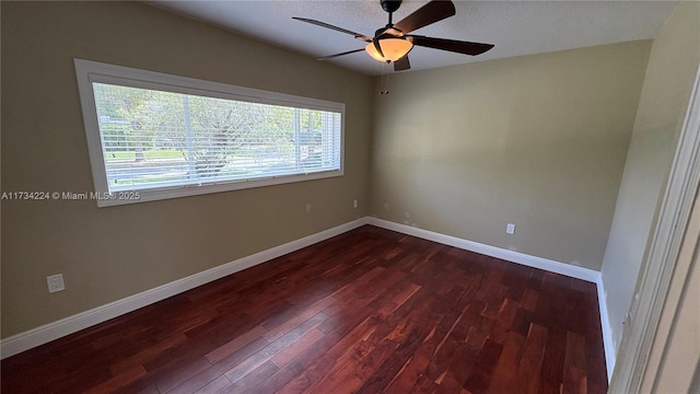 empty room with ceiling fan and dark hardwood / wood-style flooring