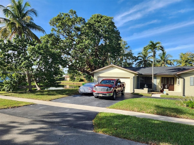 ranch-style house with a garage and a front yard