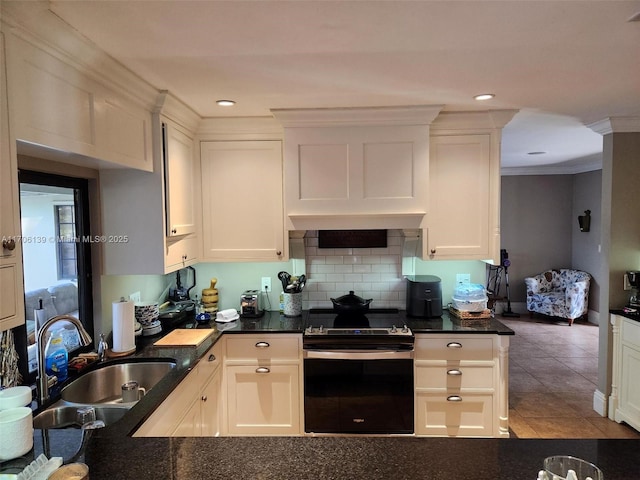 kitchen featuring range with electric stovetop, white cabinetry, sink, and ornamental molding