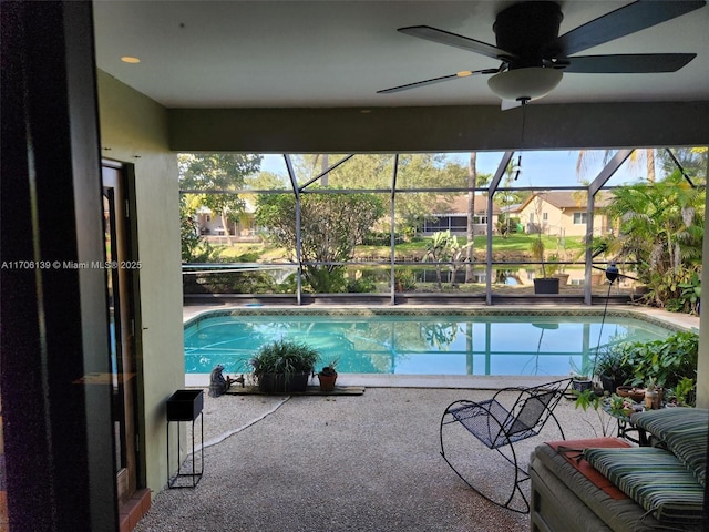 view of pool featuring ceiling fan, a patio, and glass enclosure