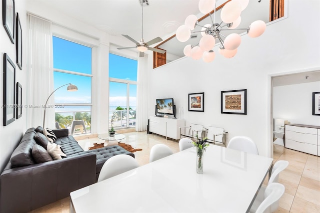 5445 Collins Ave Unit M15, Miami Beach, FL 33140 - dining space featuring light tile patterned floors, a ceiling fan, and a towering ceiling