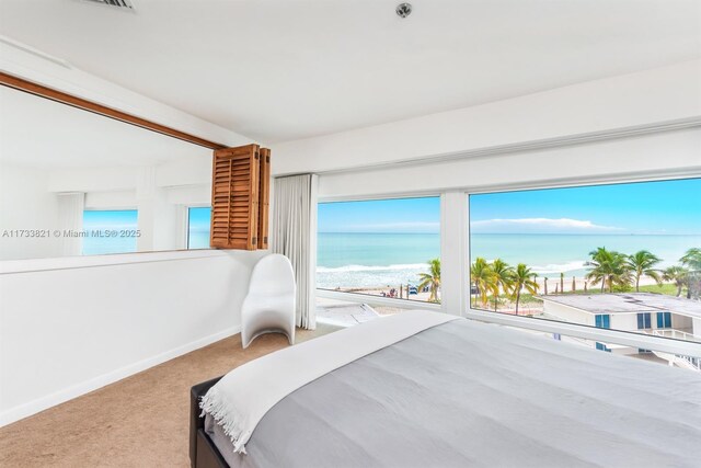 carpeted bedroom featuring a water view