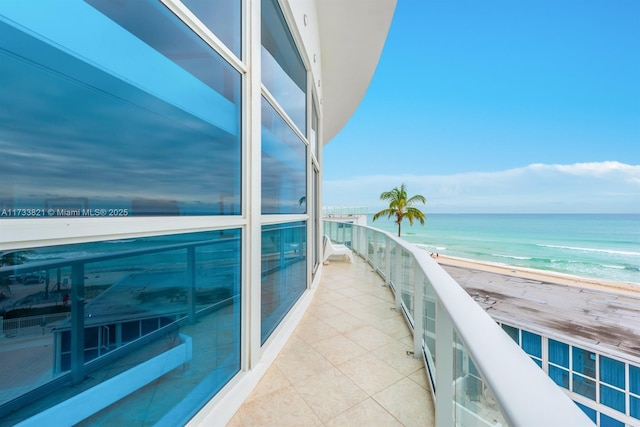 balcony featuring a beach view and a water view