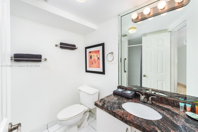 bathroom featuring an enclosed shower, vanity, tile patterned floors, and toilet