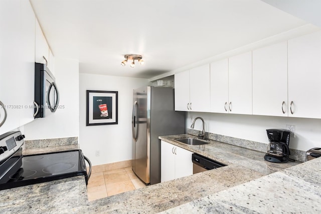5445 Collins Ave Unit M15, Miami Beach, FL 33140 - kitchen featuring white cabinetry, light stone countertops, appliances with stainless steel finishes, and a sink