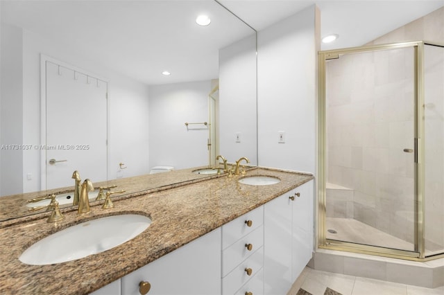 bathroom featuring a shower with door, vanity, and tile patterned floors