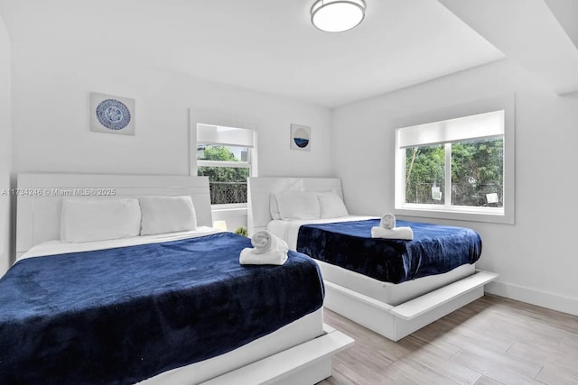 bedroom with light hardwood / wood-style floors and multiple windows