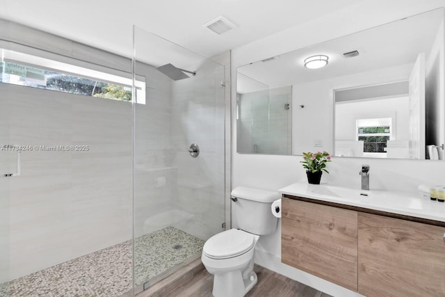 bathroom featuring vanity, hardwood / wood-style floors, toilet, and a healthy amount of sunlight