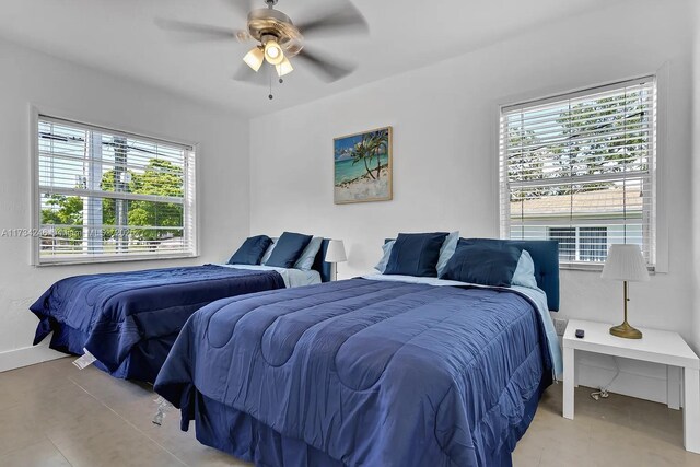 tiled bedroom featuring ceiling fan