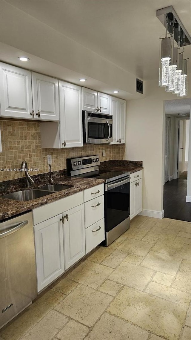 kitchen featuring white cabinetry, stainless steel appliances, sink, and decorative backsplash