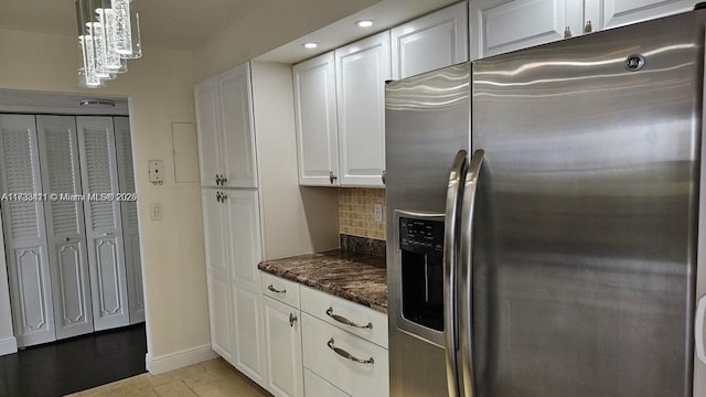 kitchen featuring white cabinets, stainless steel fridge with ice dispenser, and backsplash