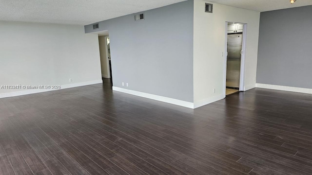 unfurnished room featuring a textured ceiling and dark hardwood / wood-style flooring