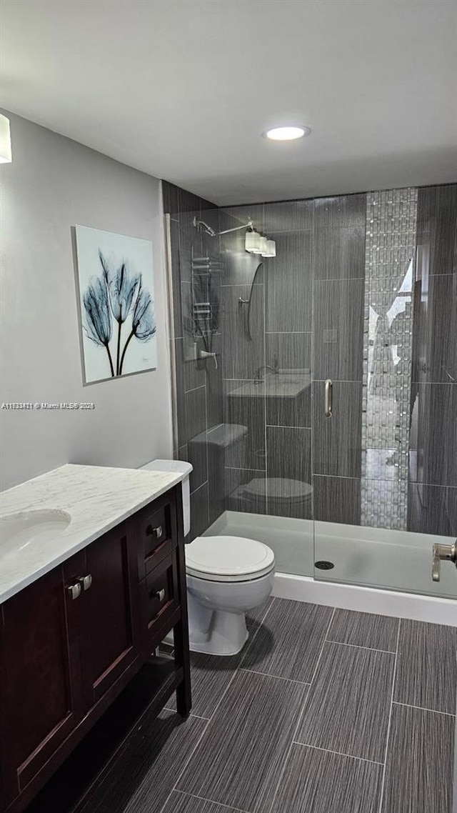 bathroom with vanity, toilet, and an enclosed shower