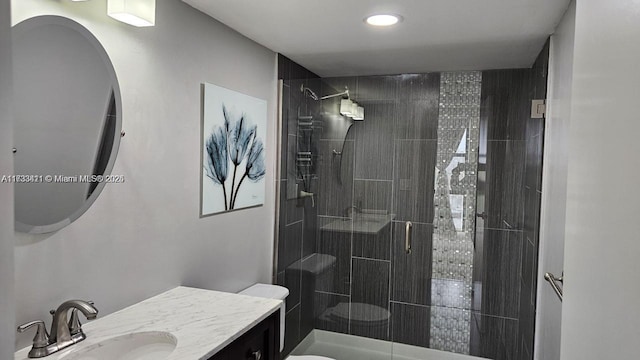 bathroom with vanity, toilet, and tiled shower