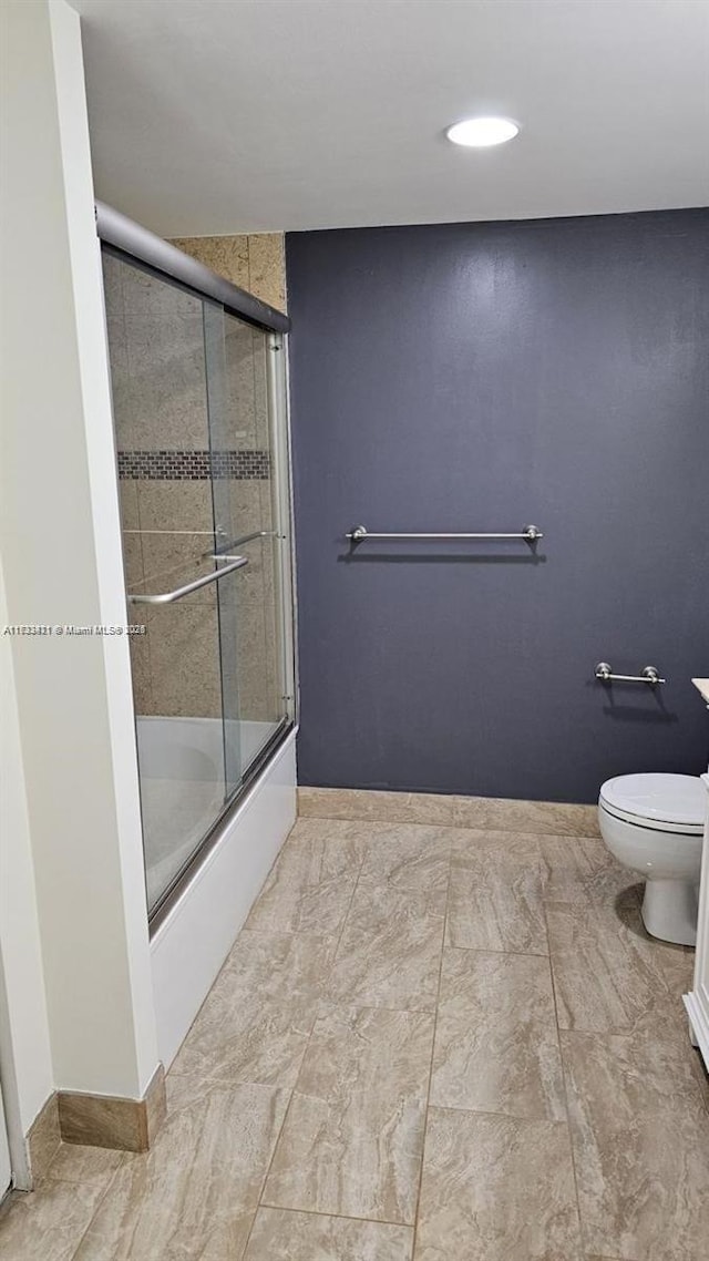 bathroom with shower / bath combination with glass door and toilet