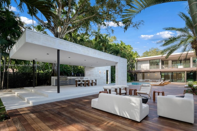 exterior space featuring an outdoor kitchen, an outdoor hangout area, and a fenced in pool