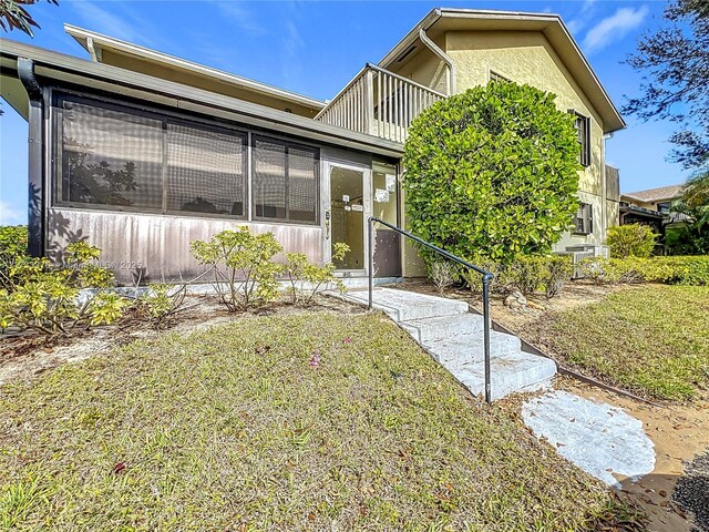 view of front of property with central AC unit and a balcony