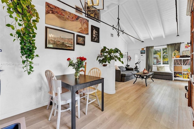 dining space featuring high vaulted ceiling, beam ceiling, and light hardwood / wood-style floors