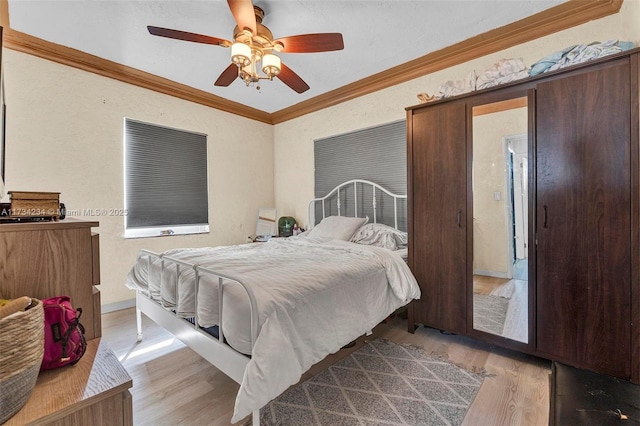 bedroom with ornamental molding, ceiling fan, and light hardwood / wood-style flooring