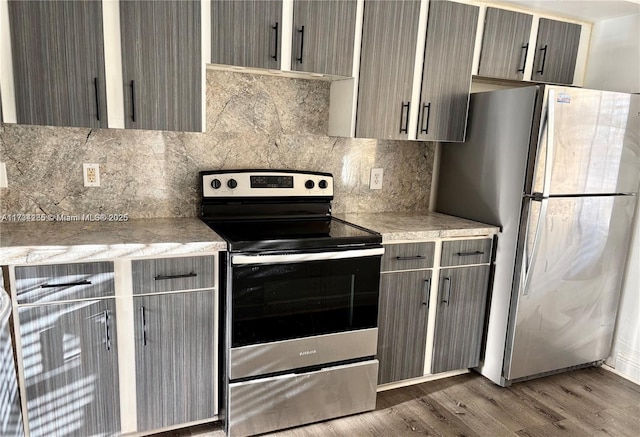 kitchen with backsplash, wood-type flooring, and stainless steel appliances