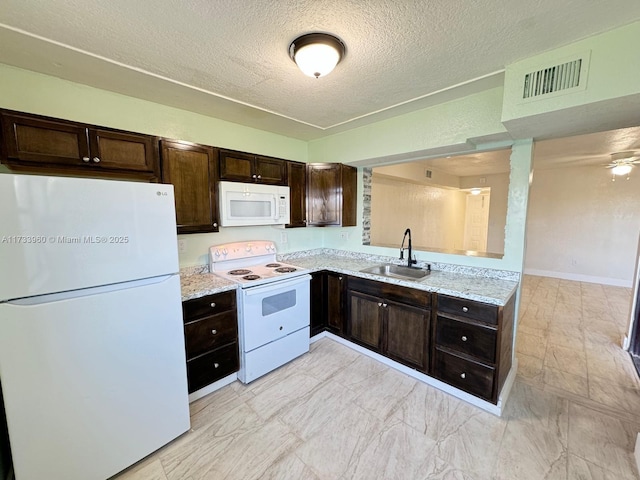 kitchen with dark brown cabinetry, sink, a textured ceiling, and white appliances