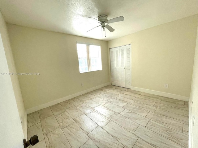 unfurnished bedroom featuring ceiling fan and a closet