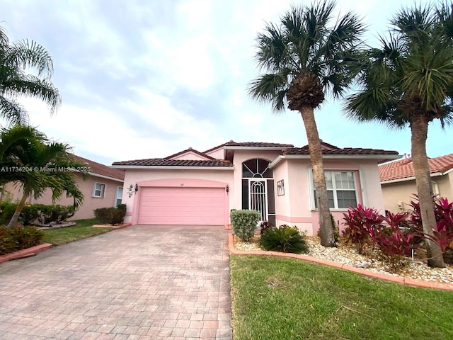 mediterranean / spanish house with a garage and a front yard