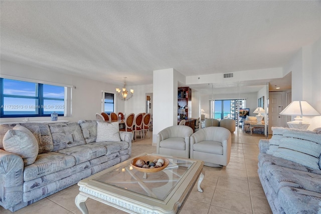 tiled living room featuring a textured ceiling and a notable chandelier