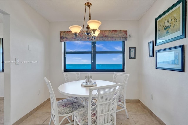 tiled dining space featuring an inviting chandelier