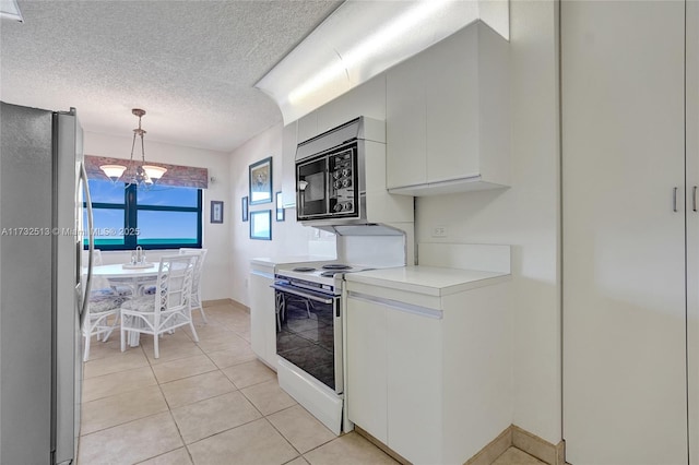 kitchen with pendant lighting, white cabinets, a chandelier, stainless steel fridge, and electric range