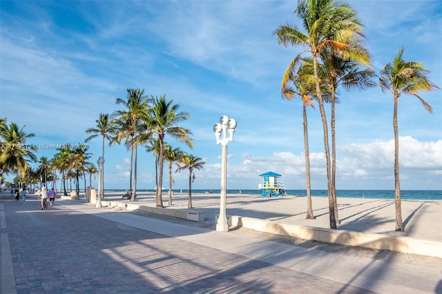 view of home's community featuring a water view, a view of the beach, and a playground