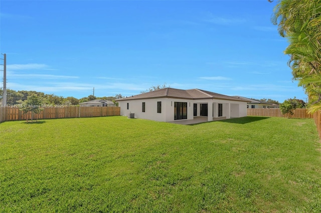 rear view of house featuring a yard and central AC unit