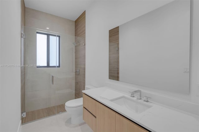 bathroom featuring a shower with door, vanity, and toilet