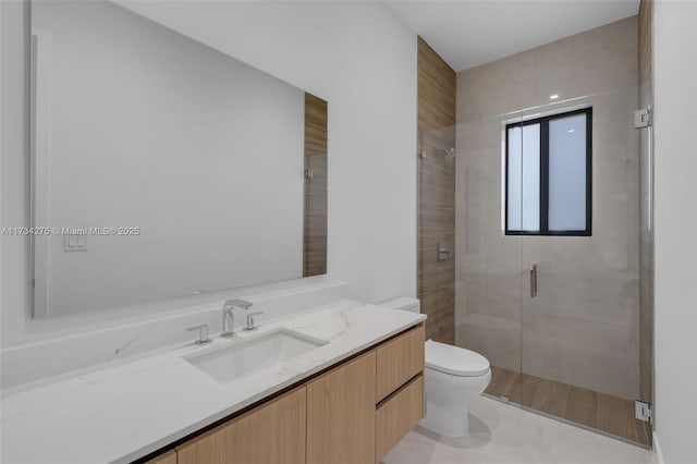 bathroom with vanity, toilet, and a shower with shower door